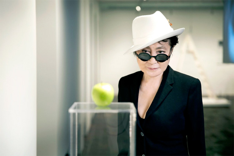 Yoko Ono looking at an apple