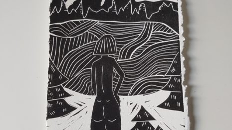 A photo of my linocut print of Nude Woman in the Mountains. The image is black and white.