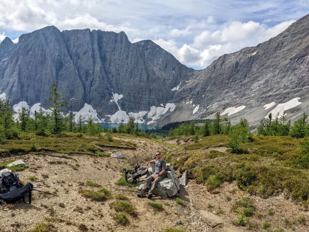 Photo of Billy with an amazing meadow and Rockwall view of Floe Lake.