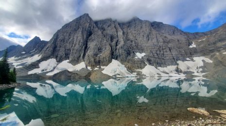 A photo of Floe Lake with a clear reflection of the mountain in the lake.