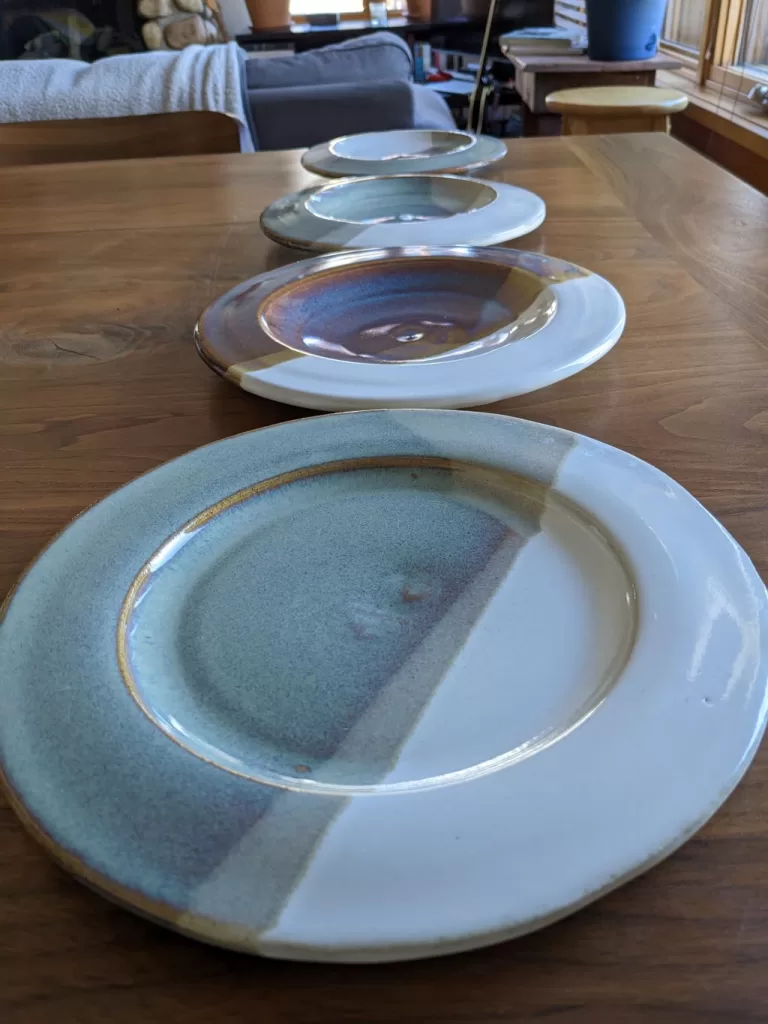 A close up of a plate with the rest of the set in the background in a row.