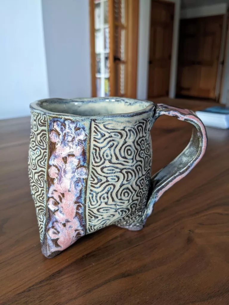 Three Footed Pottery Mug Design - with daisy flower and topography imprint.